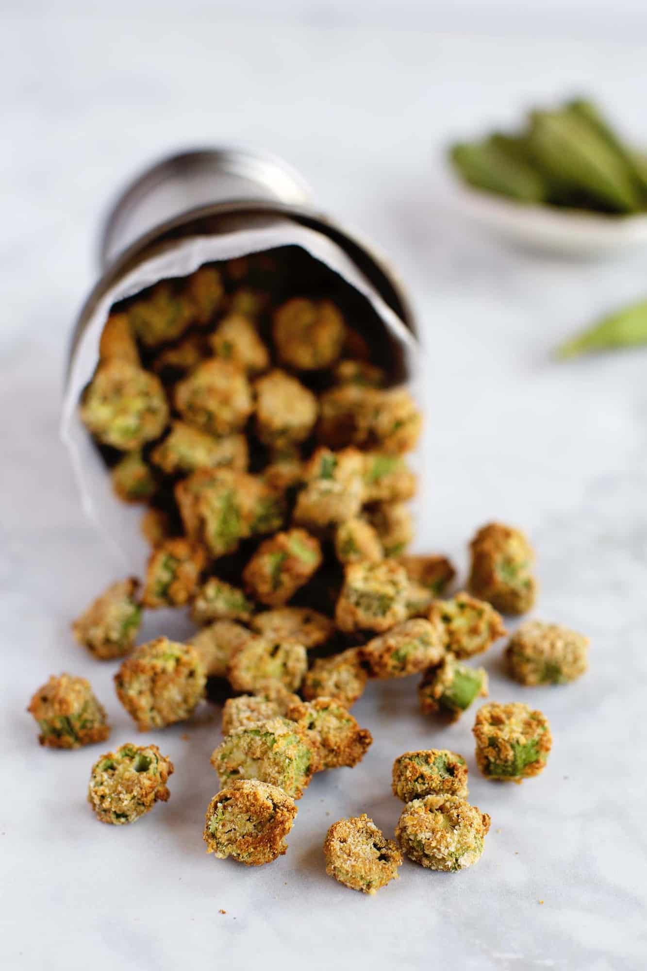 silver cup tipped over with fried okra spilling out onto countertop