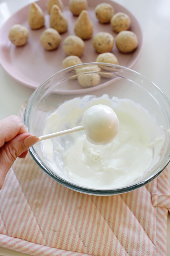 dipping cake pops into melted chocolate for christmas cake pops
