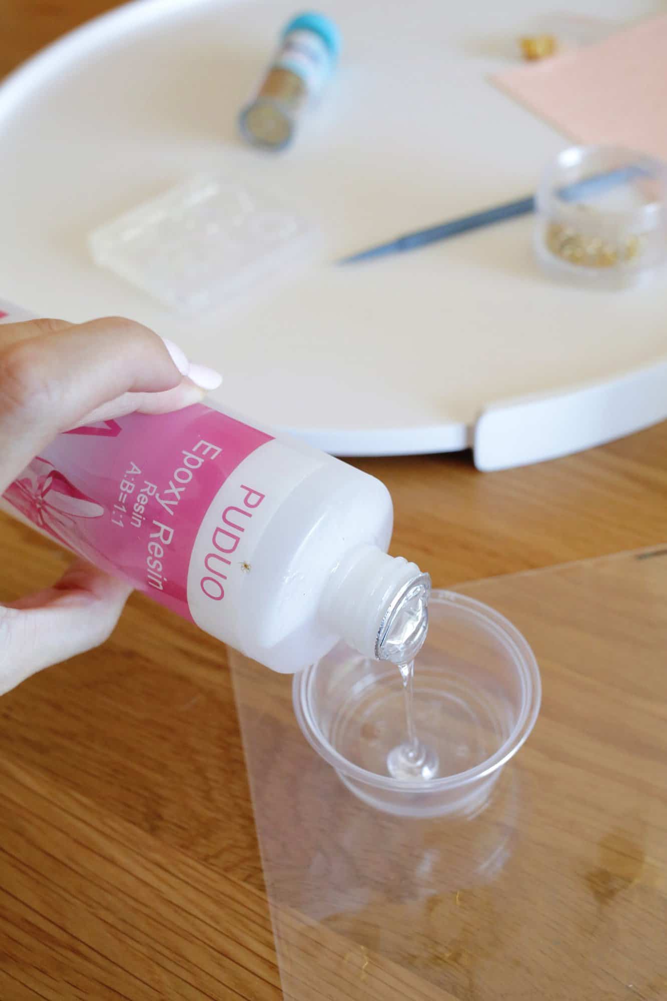 pouring epoxy ingredients into a cup